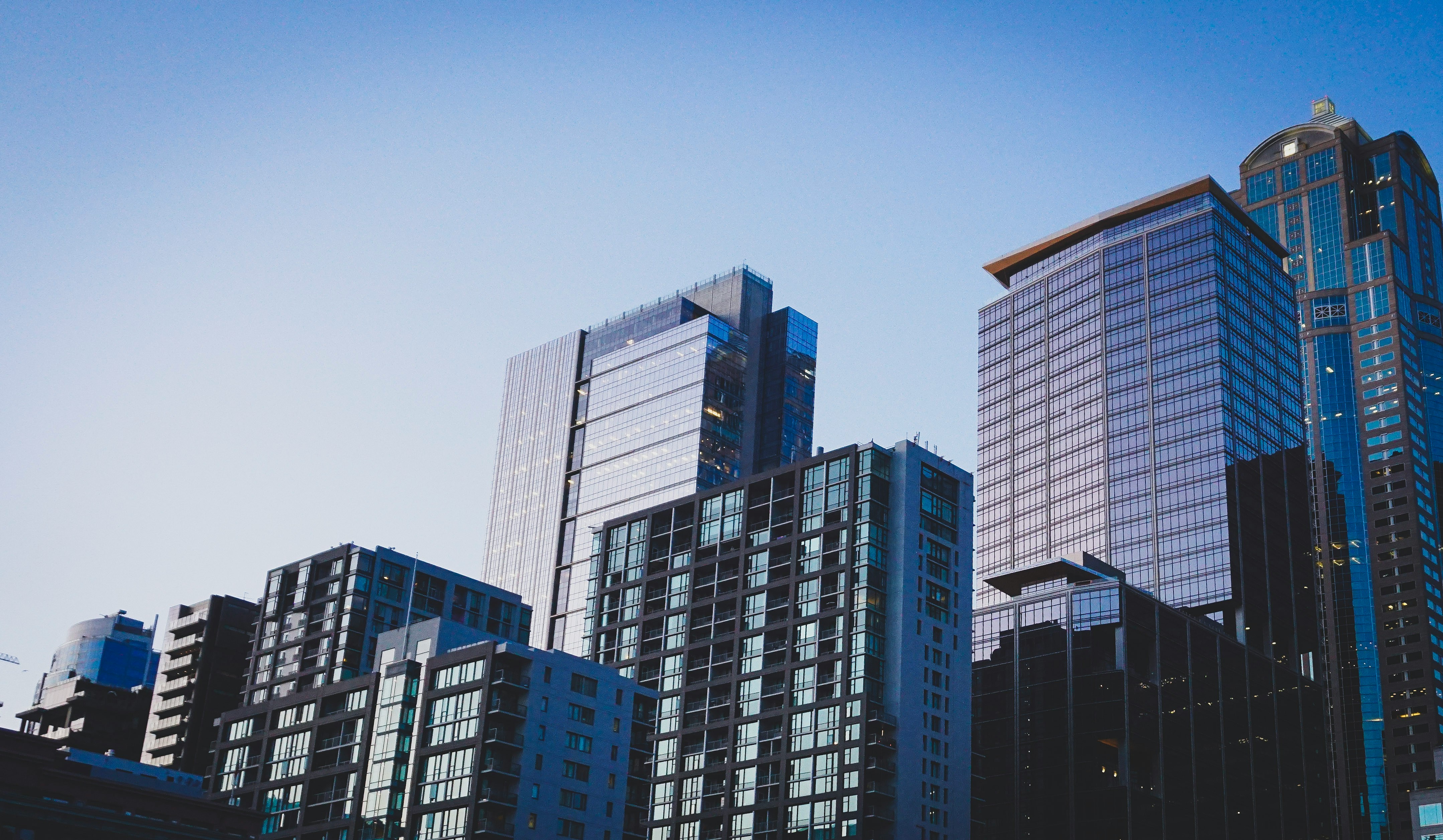 Modern city skyscrapers against a clear blue sky.